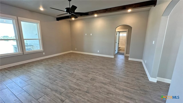 unfurnished room featuring a wealth of natural light, wood-type flooring, and ceiling fan