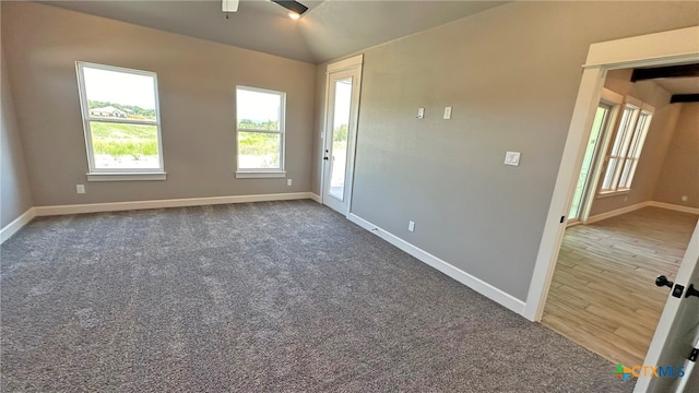 spare room featuring dark hardwood / wood-style flooring, lofted ceiling, and ceiling fan