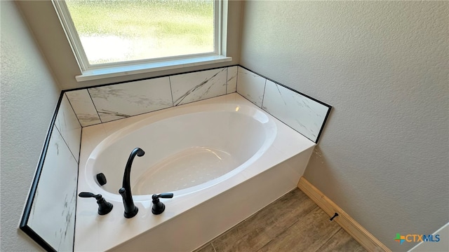 bathroom featuring a bath and wood-type flooring