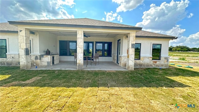 rear view of property with a lawn, ceiling fan, and a patio area