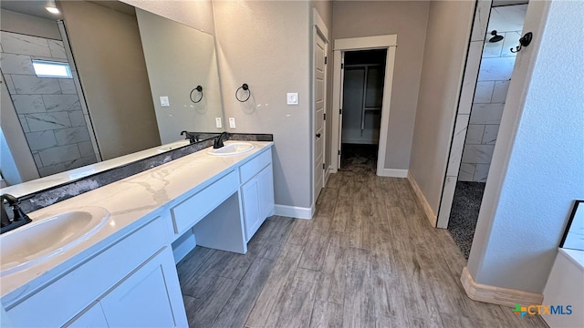 bathroom featuring vanity, hardwood / wood-style flooring, and tiled shower