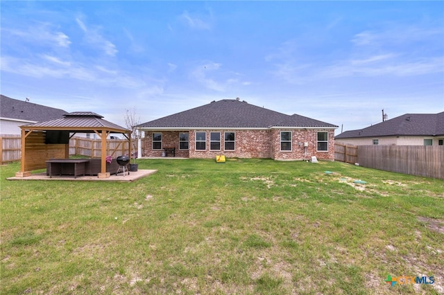 back of property featuring a fenced backyard, a patio, a gazebo, and brick siding