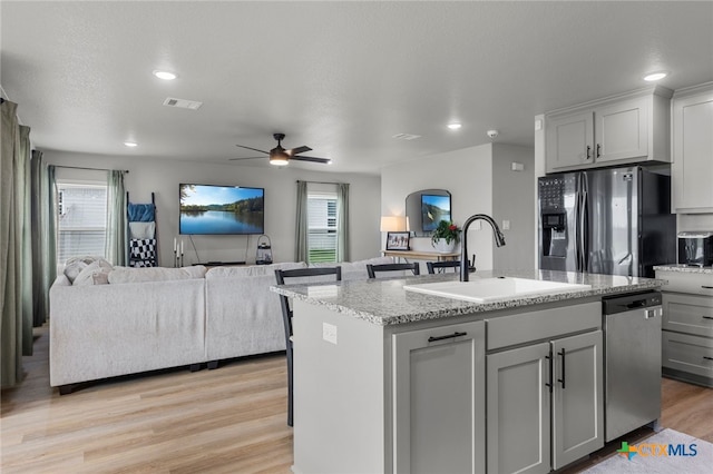 kitchen with a sink, visible vents, dishwasher, fridge with ice dispenser, and gray cabinetry