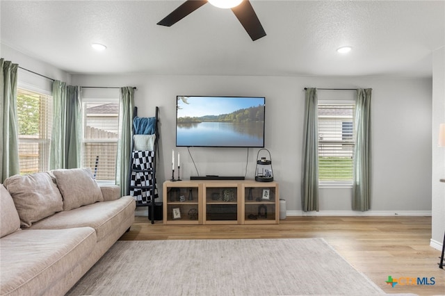 living room featuring wood finished floors, baseboards, recessed lighting, a textured ceiling, and a ceiling fan
