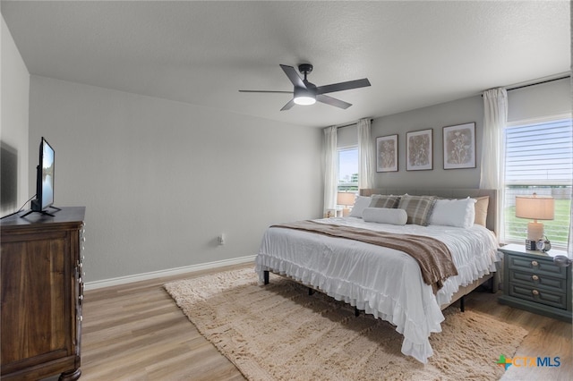 bedroom featuring light wood-style floors, baseboards, and ceiling fan