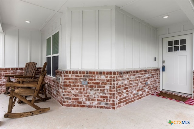entrance to property with board and batten siding and brick siding