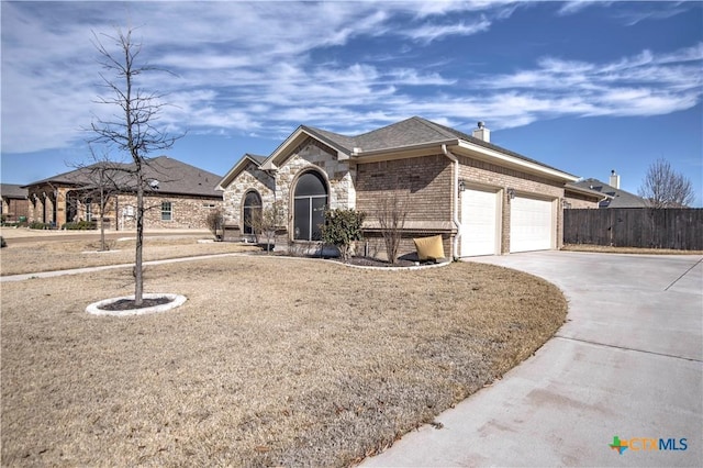 single story home with brick siding, a chimney, fence, a garage, and driveway