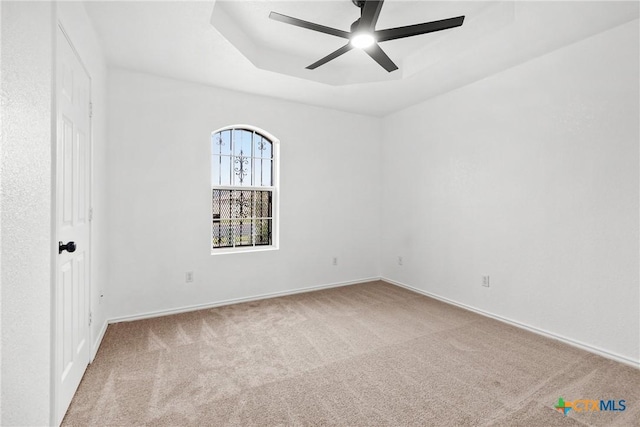 spare room with carpet flooring, ceiling fan, and baseboards