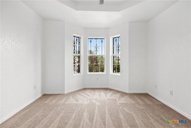 empty room featuring carpet and baseboards