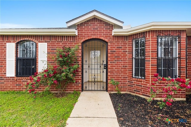 view of exterior entry featuring brick siding