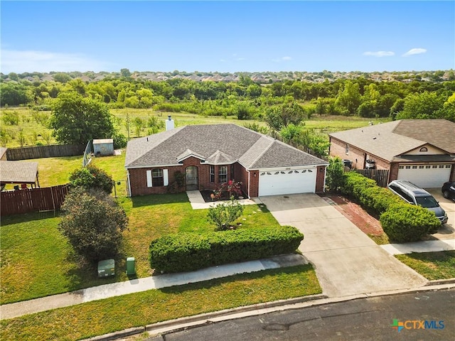 view of front of home with fence, a front lawn, concrete driveway, and an attached garage