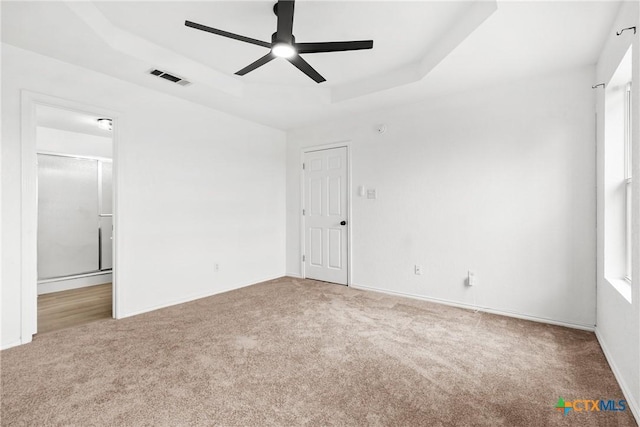 unfurnished bedroom featuring ensuite bathroom, visible vents, carpet floors, and baseboards
