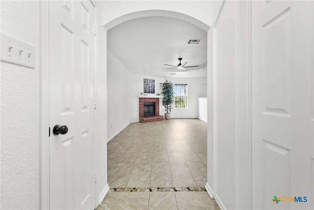 corridor featuring baseboards, visible vents, and arched walkways