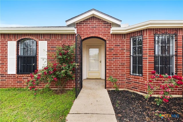view of exterior entry featuring brick siding