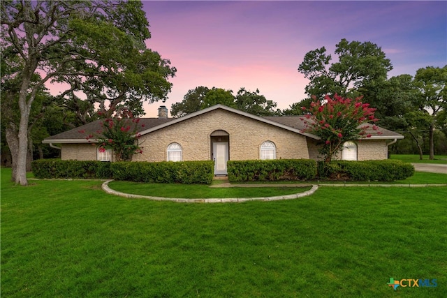 single story home with a lawn