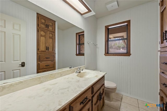 bathroom with baseboards, vanity, toilet, and tile patterned floors