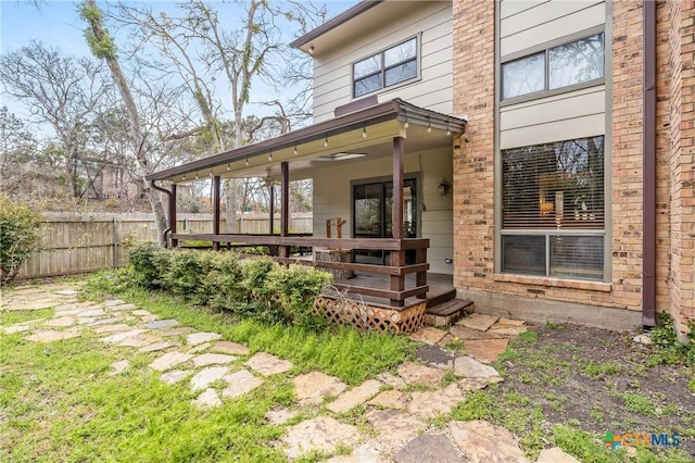 exterior space featuring fence and brick siding