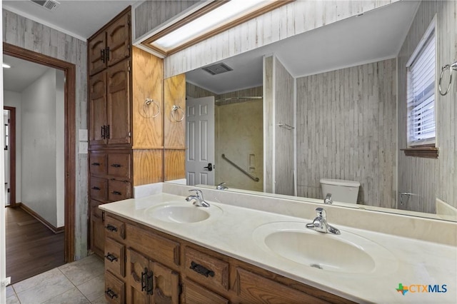 full bathroom featuring double vanity, a sink, toilet, and tile patterned floors