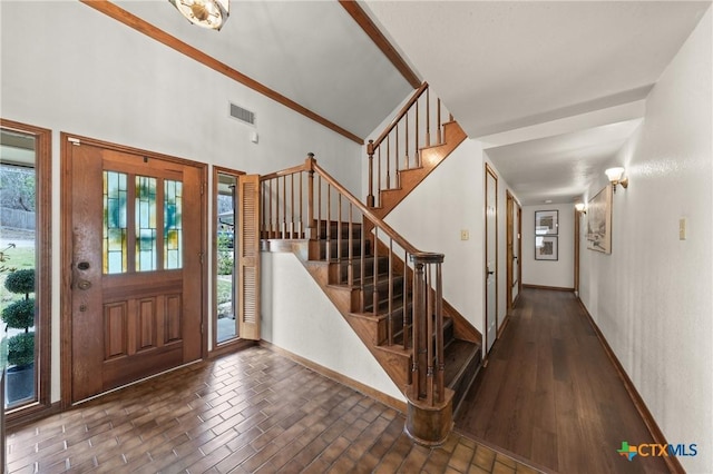 foyer entrance with plenty of natural light, brick floor, and baseboards