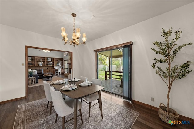 dining area featuring baseboards, wood finished floors, and an inviting chandelier