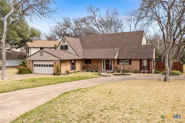 view of front facade with an attached garage, brick siding, fence, driveway, and a front lawn