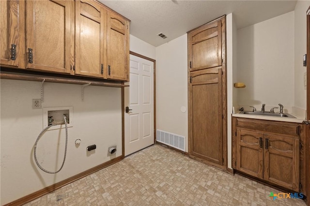 clothes washing area featuring hookup for a washing machine, cabinet space, a sink, and visible vents