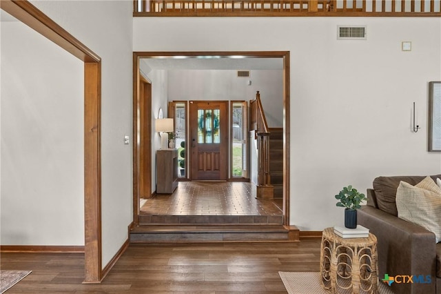 entrance foyer featuring baseboards, stairs, visible vents, and wood finished floors