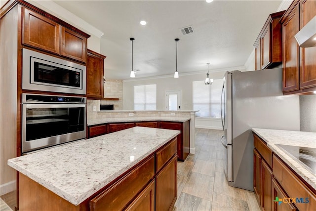 1040 Vista Dr, Salado, TX 76571 - kitchen with a center island, appliances with stainless steel finishes, a peninsula, ornamental molding, and visible vents