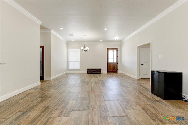 1040 Vista Dr, Salado, TX 76571 - unfurnished living room with light wood-style flooring, visible vents, an inviting chandelier, and ornamental molding