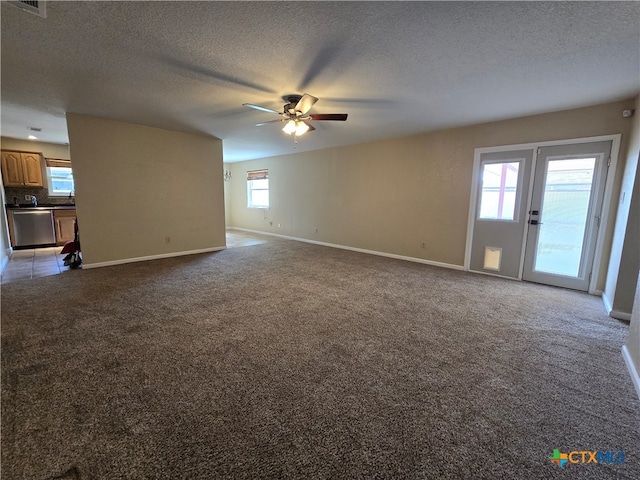 unfurnished living room with a textured ceiling, light colored carpet, and ceiling fan