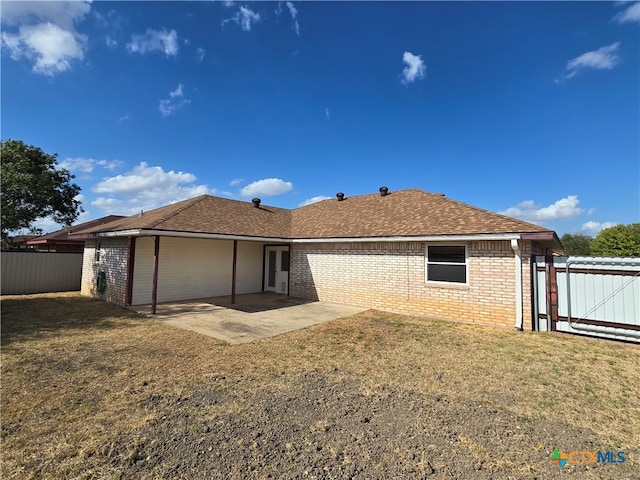 back of property with a patio area and a lawn