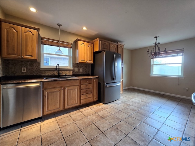 kitchen featuring plenty of natural light, a chandelier, sink, and stainless steel appliances