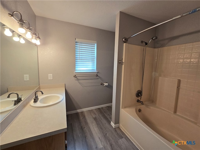 bathroom featuring tiled shower / bath combo, vanity, hardwood / wood-style floors, and a textured ceiling