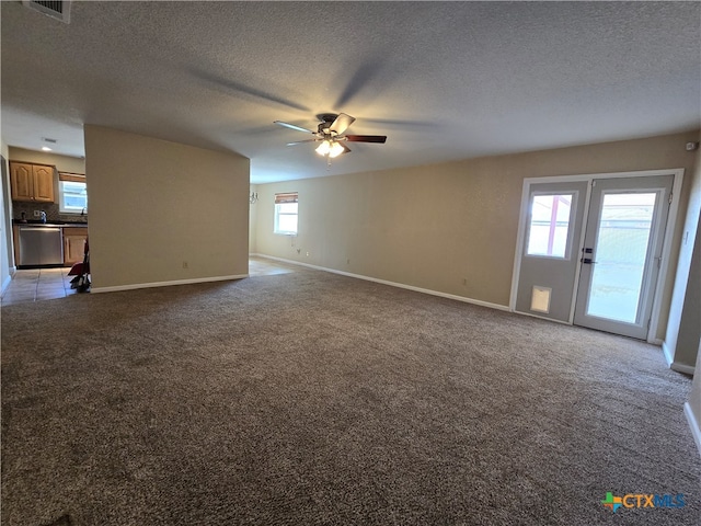 unfurnished living room with a wealth of natural light, ceiling fan, and a textured ceiling