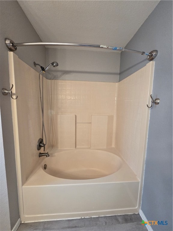 bathroom featuring a textured ceiling and shower / bathing tub combination