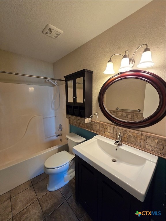 full bathroom featuring a textured ceiling, vanity, tile patterned floors, toilet, and shower / bathtub combination