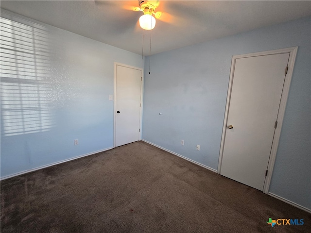 spare room featuring ceiling fan and carpet floors