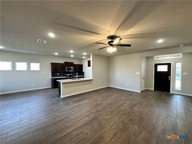 3002 Gryffindor Ln, Killeen, TX 76549 - unfurnished living room featuring a textured ceiling, dark wood-type flooring, a ceiling fan, baseboards, and recessed lighting