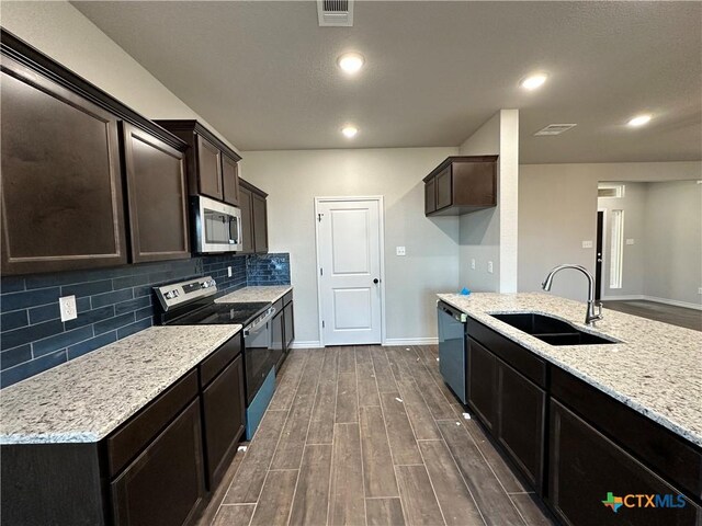 3002 Gryffindor Ln, Killeen, TX 76549 - kitchen with appliances with stainless steel finishes, a sink, dark wood-style flooring, decorative backsplash, and dark brown cabinetry