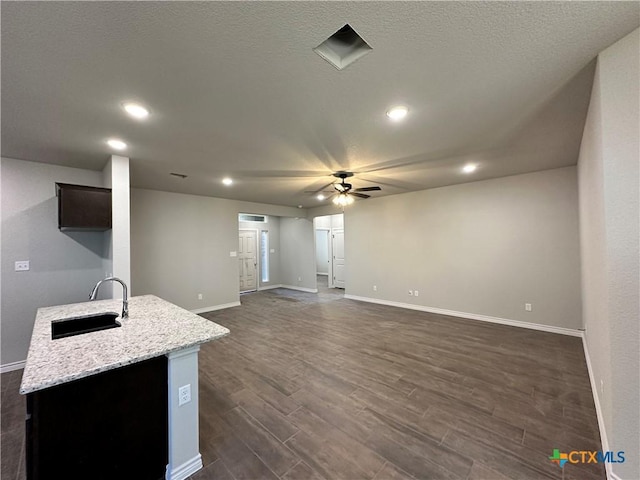 kitchen featuring dark hardwood / wood-style floors, ceiling fan, light stone countertops, and sink