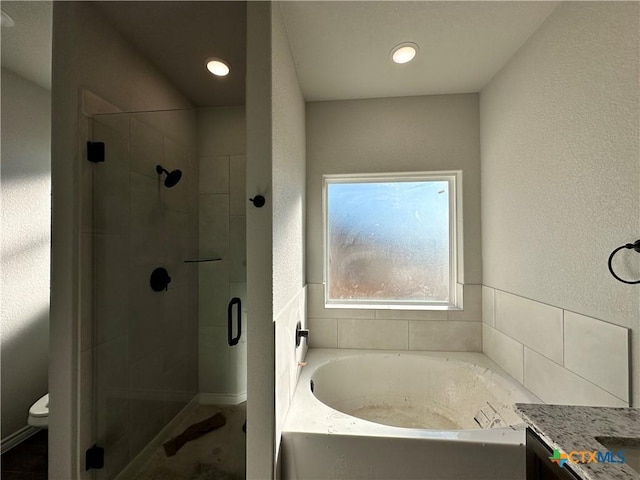 full bathroom featuring vanity, separate shower and tub, and toilet