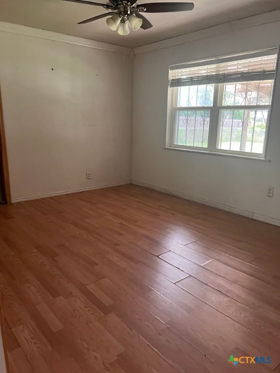 spare room featuring ornamental molding, wood-type flooring, and ceiling fan