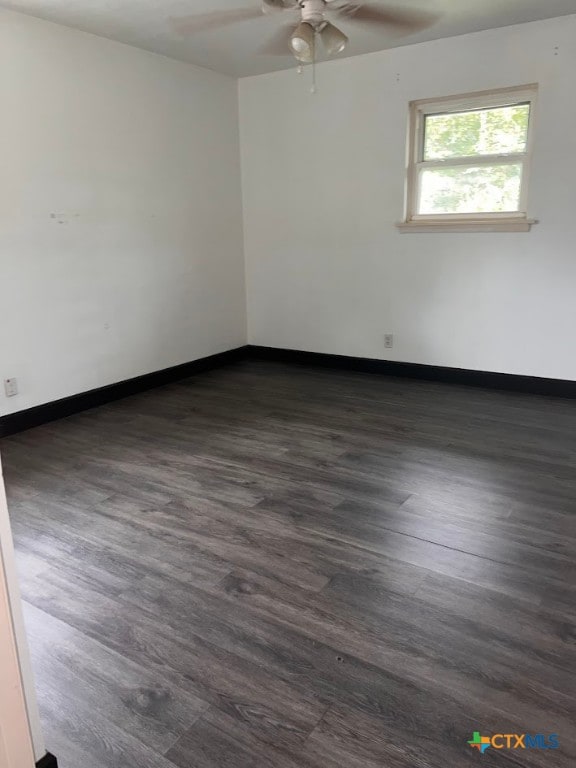 spare room with ceiling fan and dark hardwood / wood-style flooring