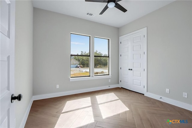 unfurnished bedroom featuring baseboards, ceiling fan, and visible vents