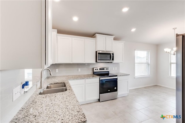 9019 Stonehollow Rd, Temple, TX 76502 - kitchen featuring appliances with stainless steel finishes, a sink, white cabinets, light stone counters, and a chandelier