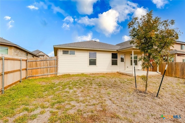 rear view of house with a yard and a patio