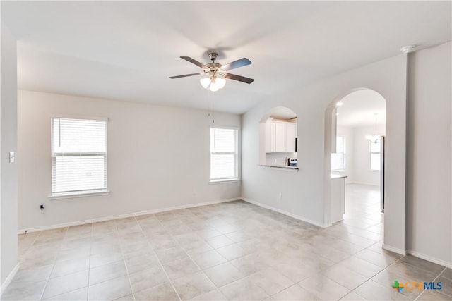 9019 Stonehollow Rd, Temple, TX 76502 - unfurnished living room featuring ceiling fan, light tile patterned floors, baseboards, and arched walkways