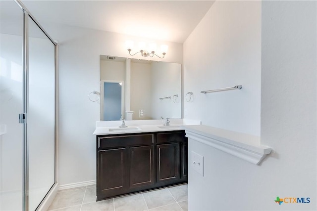 9019 Stonehollow Rd, Temple, TX 76502 - bathroom featuring double vanity, a stall shower, a chandelier, tile patterned floors, and baseboards