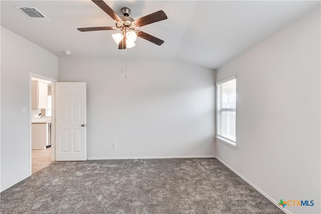 spare room with dark colored carpet, ceiling fan, and vaulted ceiling