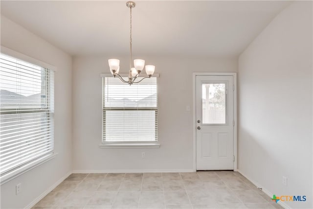 unfurnished dining area with a notable chandelier, plenty of natural light, and light tile patterned flooring